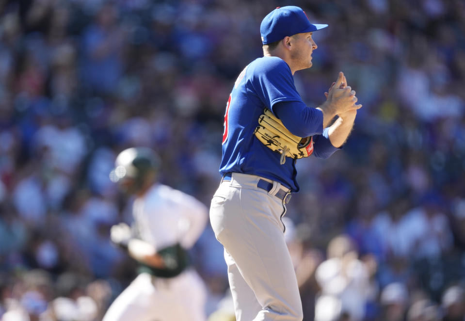 Chicago Cubs relief pitcher Hayden Wesneski, front, rubs a new ball after giving up a solo home run ato Colorado Rockies' Kris Bryant in the seventh inning of a baseball game Wednesday, Sept. 13, 2023, in Denver. (AP Photo/David Zalubowski)