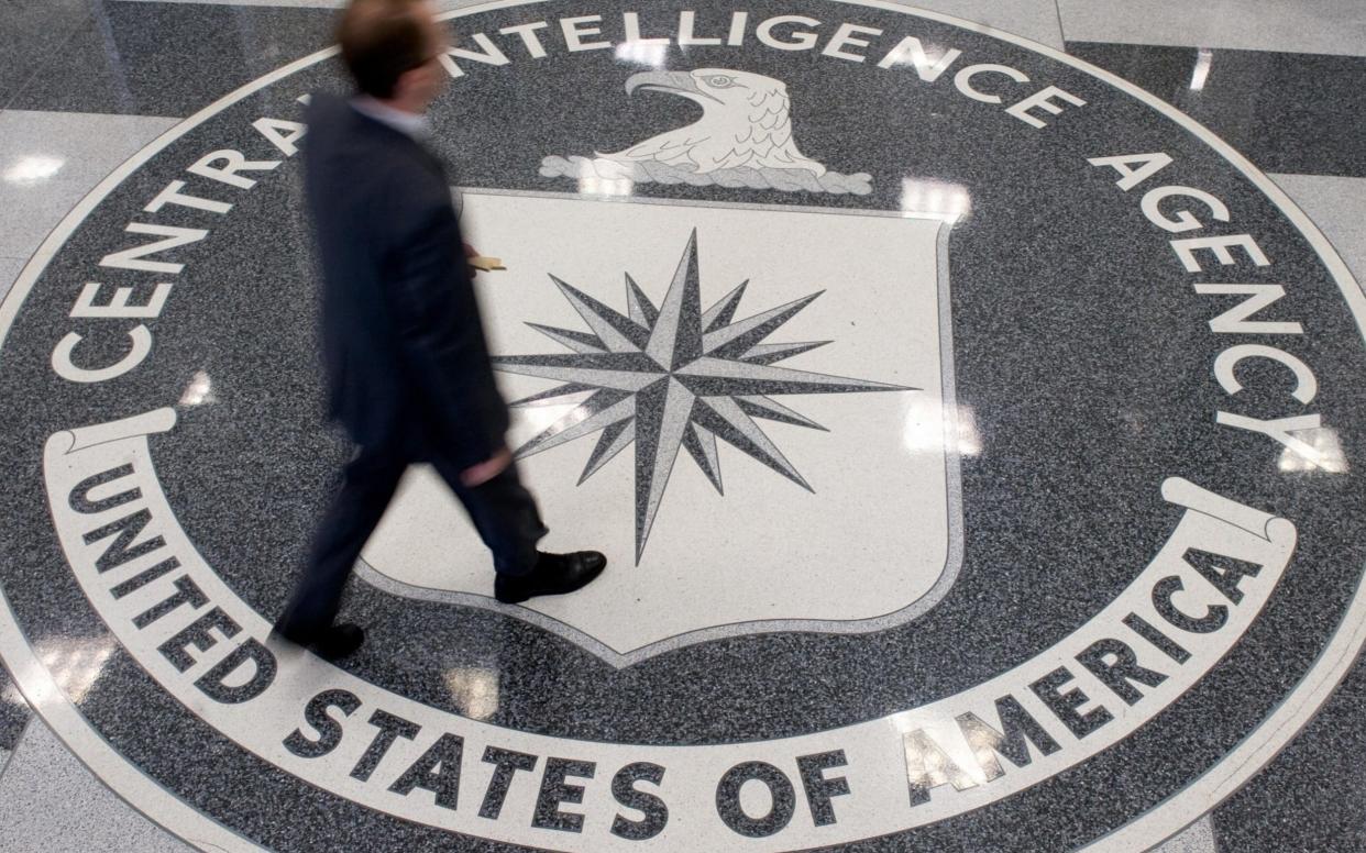 A man crosses the Central Intelligence A...A man crosses the Central Intelligence Agency (CIA) logo in the lobby of CIA Headquarters in Langley, Virginia - AFP