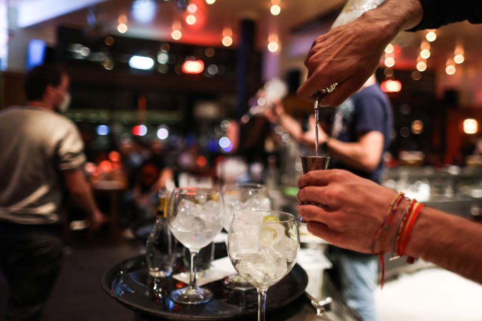 A waiter serves a cocktail at a bar on the eve of the mandatory closure of bars in Brussels (AFP via Getty Images)