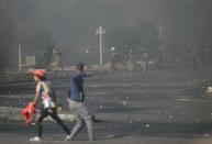 Iraqi security forces are seen as they clash with demonstrators during ongoing anti-government protests in Nassiriya