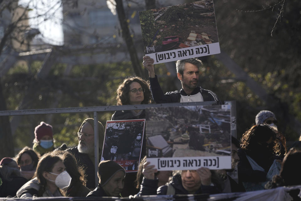 FILE - Protesters hold pictures of a demolished home that left some 15 people homeless, in a show of solidarity with Palestinian residents of the embattled Sheikh Jarrah neighborhood of east Jerusalem, Jan. 21, 2022. Israel’s Supreme Court ruled Tuesday, March 1, 2022, that Palestinian families slated for eviction from their east Jerusalem homes can remain for the time being. The families are among dozens in Jerusalem who are threatened with eviction by Jewish settler organizations. The Hebrew on the sign reads," this is what occupation looks like." (AP Photo/Mahmoud Illean, File)