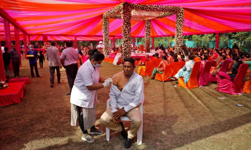 A wedding guest gets a Covid vaccine dose during a quiet moment.