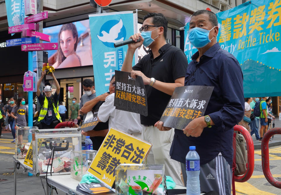 In this July. 1, 2020, file photo, Hong Kong media tycoon Jimmy Lai, right, stands next to democratic lawmaker Lam Cheuk-ting, during a fund-raising event before the annual July 1 handover march in Hong Kong. A national security law enacted in 2020 and COVID-19 restrictions have stifled major protests in Hong Kong including an annual march on July 1. (AP Photo/Vincent Yu)