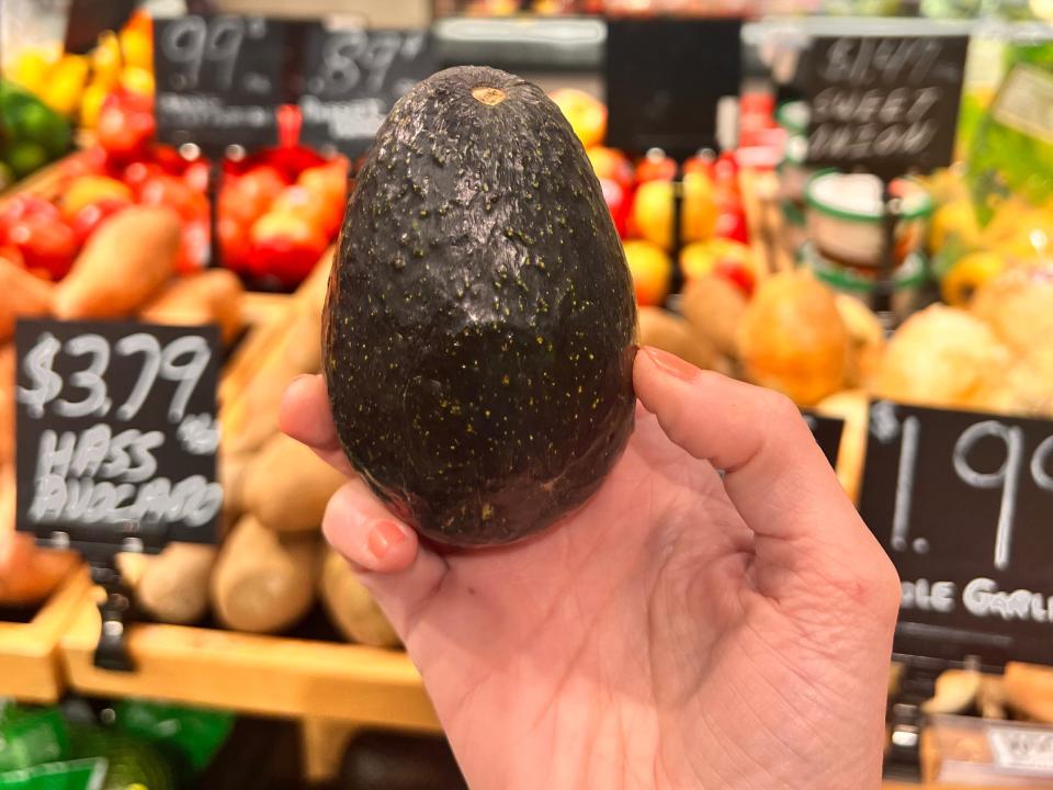 hand holding up an avocado in a target
