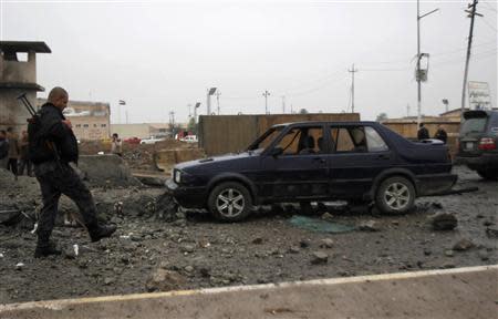 Iraqi security forces personnel inspect the site after an attack by gunmen and suicide bombers on a police intelligence headquarters and a shopping mall in Kirkuk, 250 km (155 miles) north of Baghdad, December 5, 2013. REUTERS/Ako Rasheed