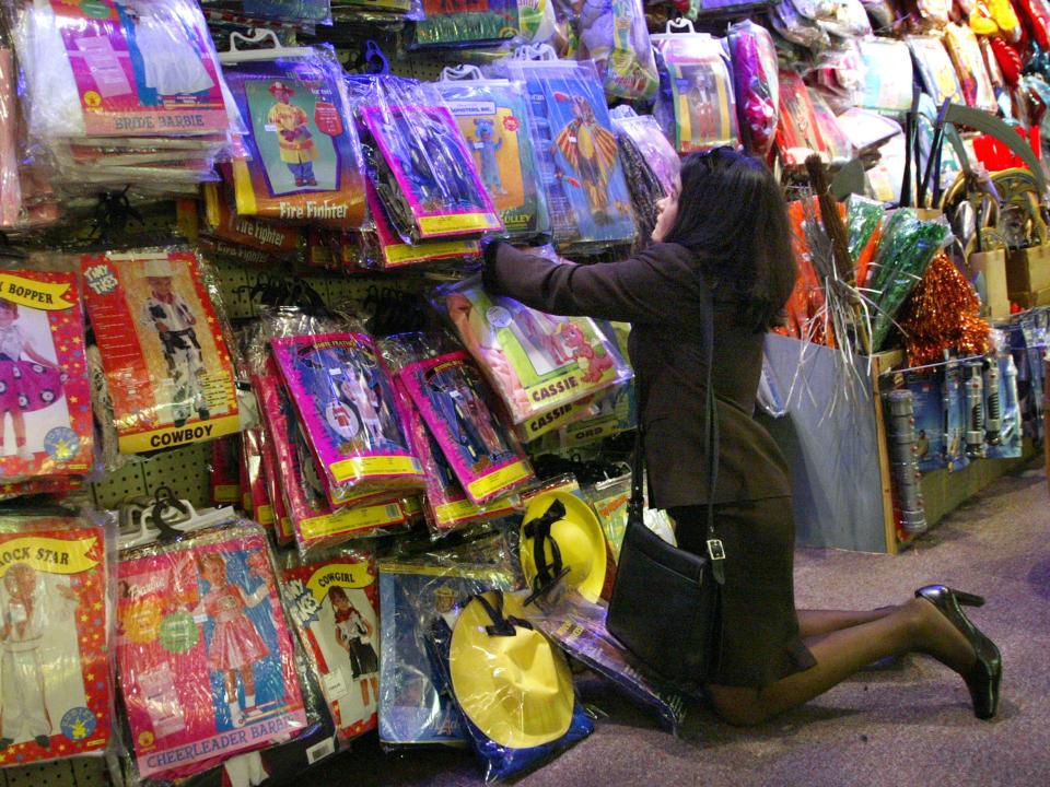 A woman looks through Halloween costumes at a store