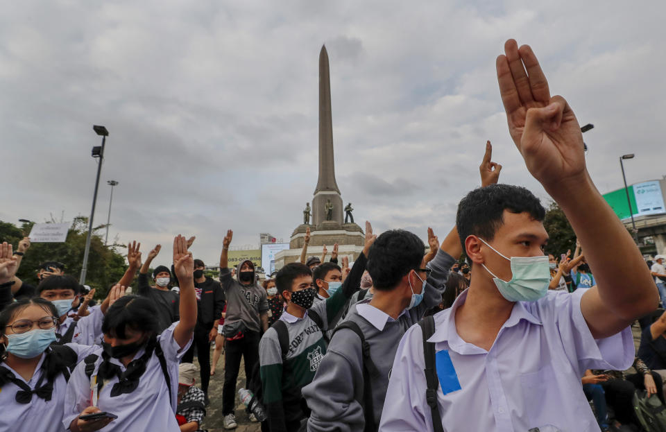 School children in school uniforms, with duct-tape covering their school names and emblems, participate in a pro-democracy rally at Victory Monument in Bangkok, Thailand, Wednesday, Oct. 21, 2020. Student activists applied to a Bangkok court Wednesday to revoke a state of emergency the government declared last week to try to rein in Thailand's growing protests. Demonstrations have continued daily in a movement that calls for Prime Minister Prayuth Chan-ocha to step down, for a more democratic constitution and for reforms to the monarchy — a revered institution traditionally treated as sacrosanct in Thailand. (AP Photo/Sakchai Lalit)