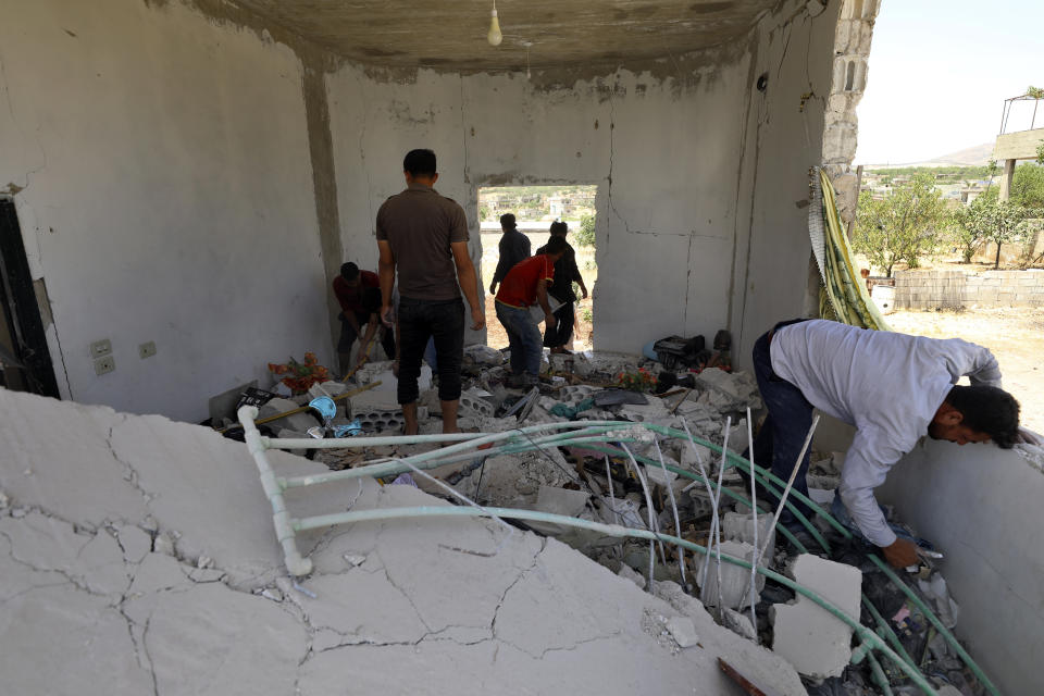 People inspect a damage house after shelling hit the town of Ibleen, a village in southern Idlib province, Syria, Saturday, July 3, 2021. Artillery fire from government-controlled territory Saturday killed at least eight civilians in Syria's last rebel enclave, most of them children, rescue workers and a war monitor said. (AP Photo/Ghaith Alsayed)