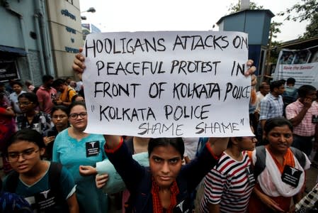 A doctor holds a placard at a government hospital during a strike demanding security after the recent assaults on doctors by the patients' relatives, in Kolkata