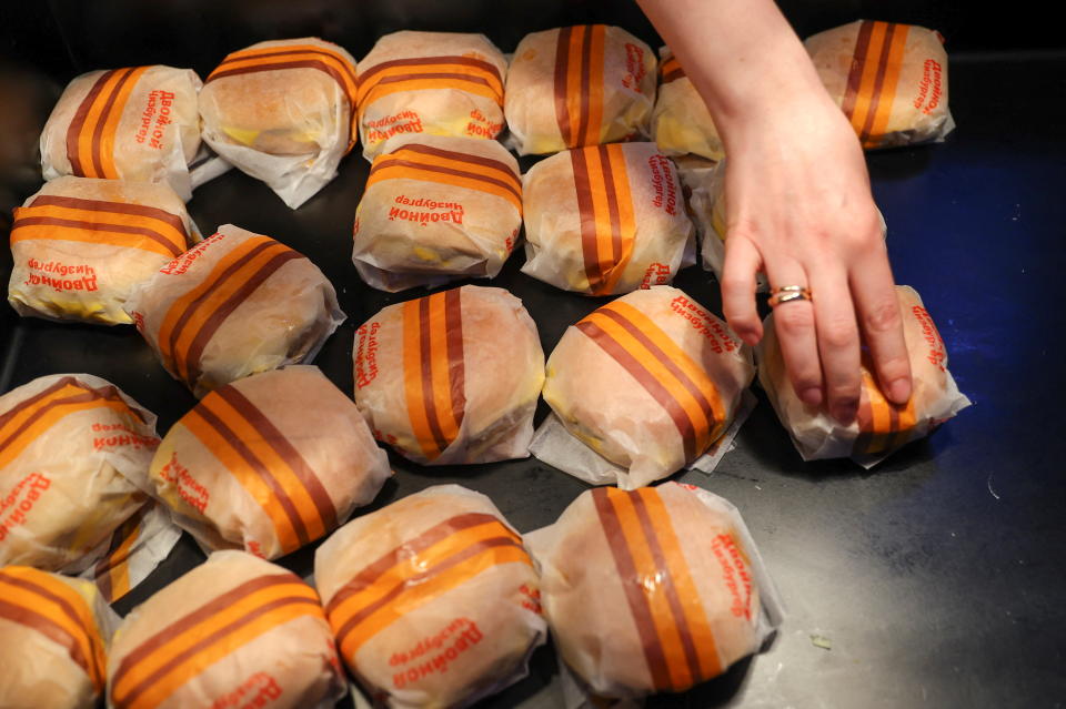 An employee places burgers at the new restaurant 