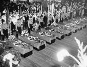 <p>Funeral services for the 28 Germans who lost their lives in the Hindenburg disaster May 6 are held on the Hamburg-American pier in New York City, May 11, 1937. The swastika-draped caskets will be placed on board the Hamburg for their return to Europe. About 10,000 members of German organizations line the pier. (AP Photo/Anthony Camerano) </p>