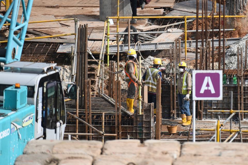 Migrant workers work at a construction site in Singapore on August 20, 2020. - About 86 per cent of foreign workers in the construction, marine and process sectors have been allowed to resume work, up from the 81 per cent announced last week, as the Ministry of Manpower announced on August 19 that all dormitories housing migrant workers were declared cleared of the COVID-19 novel coronavirus. (Photo by Roslan RAHMAN / AFP) (Photo by ROSLAN RAHMAN/AFP via Getty Images)