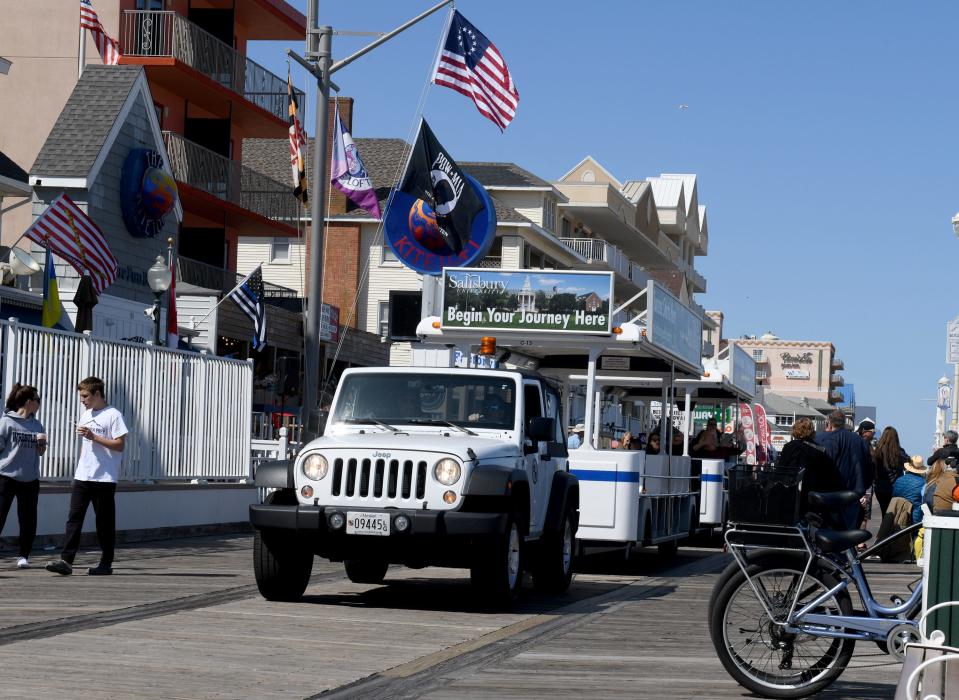 People take a ride on the tram as it drives on the boardwalk Friday, April 29, 2022, in Ocean City, Maryland.