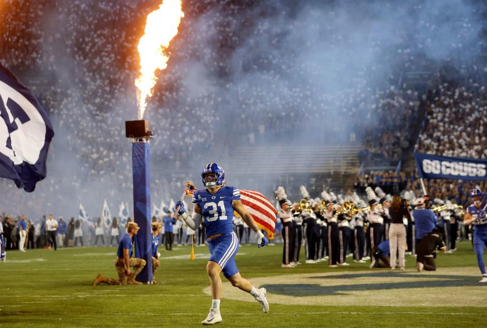 The Brigham Young Cougars run onto the field to play the Cincinnati Bearcats in a football game at LaVell Edwards Stadium in Provo on Friday, Sept. 29, 2023. | Kristin Murphy, Deseret News