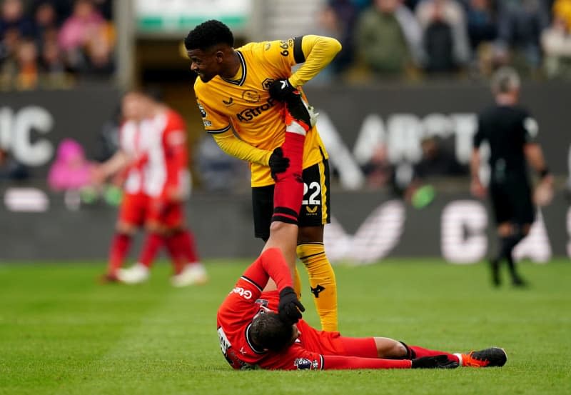 Wolverhampton Wanderers' Nelson Semedo attends to Sheffield United's Vinicius Souza after picking up an injury during the English Premier League soccer match between Wolverhampton Wanderers and Sheffield United at Molineux Stadium. David Davies/PA Wire/dpa