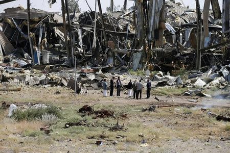 Workers and journalists inspect damage at the Alsonidar Group's water pumps and pipes factory one day after it was hit for the second time by Saudi-led air strikes in Sanaa, Yemen September 22, 2016. REUTERS/Khaled Abdullah