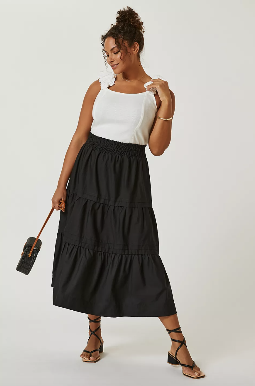 plus size model in white tank top and The Somerset Maxi Skirt in black (photo via Anthropologie)