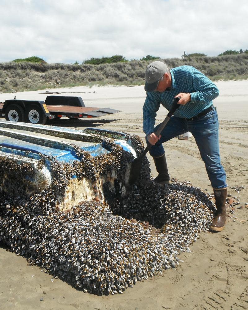 John Chapman inspecting a Japanese vessel which washed ashore on Long Beach, Washington