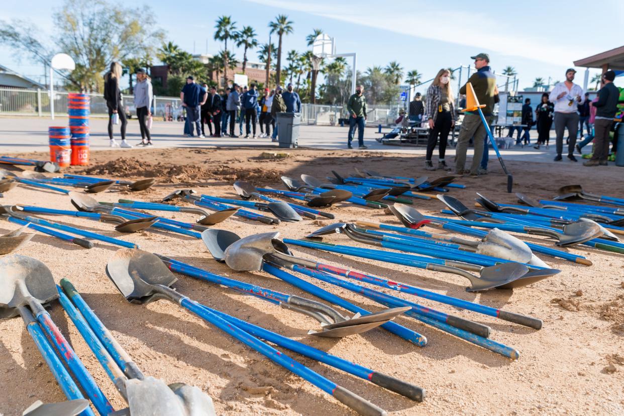 Shovels lie on the ground for volunteers to use at a tree planting event hosted by the Arizona Sustainability Alliance at Emerson Elementary School in Phoenix on Feb. 27, 2022.