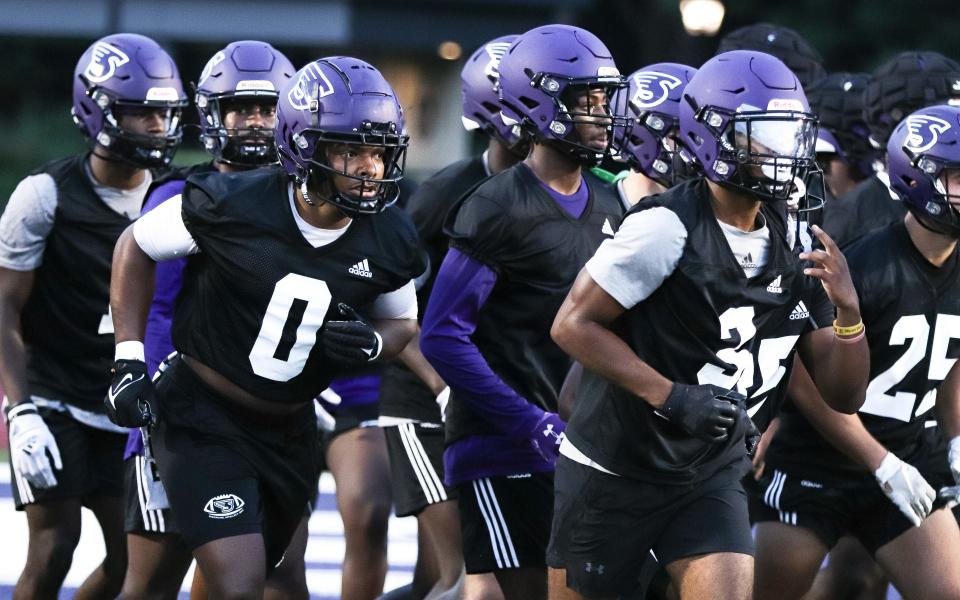 Stonehill's Micah Brown, left, jogs into the huddle during the first day of practice at W.B. Mason Stadium on Monday, Aug. 7, 2023.