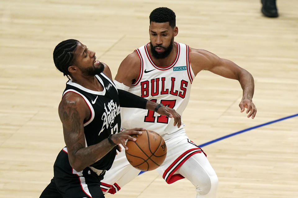 Los Angeles Clippers guard Paul George, left, dribbles next to Chicago Bulls guard Garrett Temple (17) during the first half of an NBA basketball game Sunday, Jan. 10, 2021, in Los Angeles. (AP Photo/Marcio Jose Sanchez)