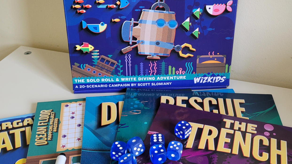  The box, dice, and scenarios of Bargain Basement Bathysphere on a white table 