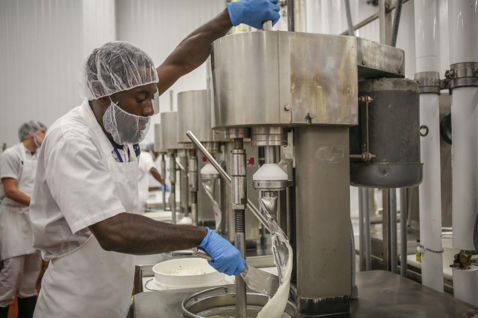 An ice cream technician for Graeter's Ice Cream prepares a mixer for the pouring of chocolate to complete a batch of mint chocolate chip ice cream.