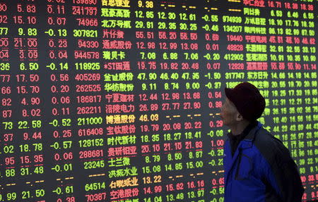 An investor looks at an electronic board showing stock information at a brokerage house in Hangzhou, Zhejiang province, China, December 2, 2015. REUTERS/China Daily CHINA OUT. NO COMMERCIAL OR EDITORIAL SALES IN CHINA