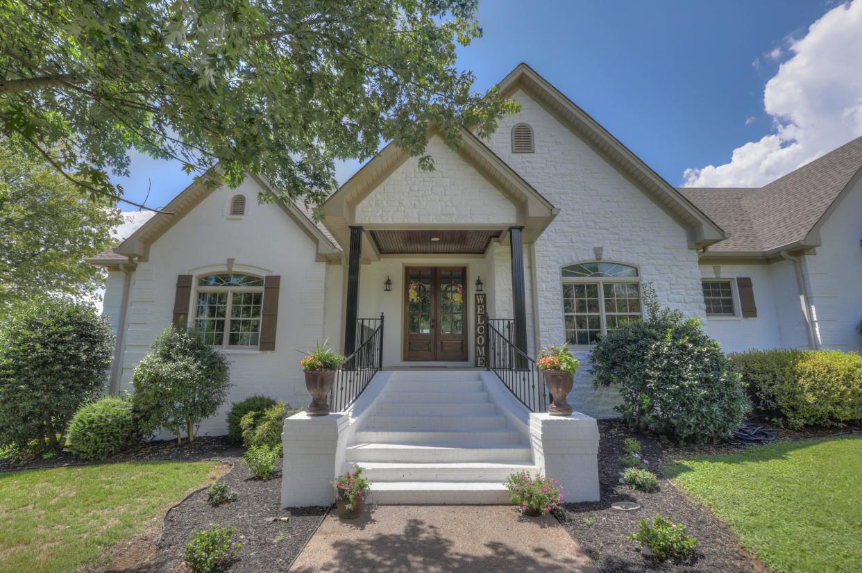 The facade of 1062 Lakeshore Drive features a gabled portico and double doors.