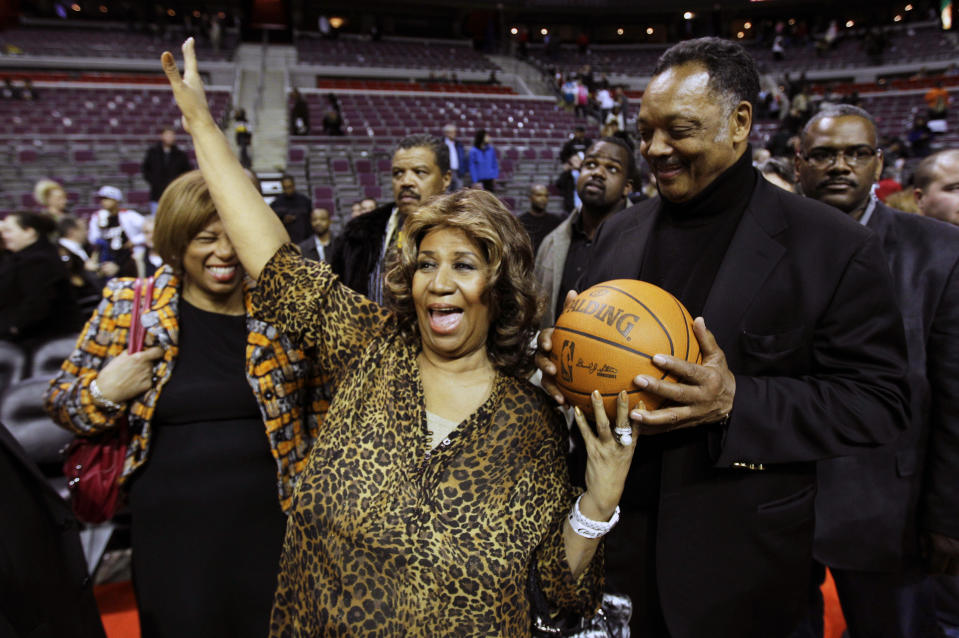 FILE - In this Feb. 11, 2011 file photo, Aretha Franklin walks on the court with Jesse Jackson after the Detroit Pistons-Miami Heat NBA basketball game in Auburn Hills, Mich. Franklin died Thursday, Aug. 16, 2018 at her home in Detroit. She was 76. (AP Photo/Paul Sancya, File)