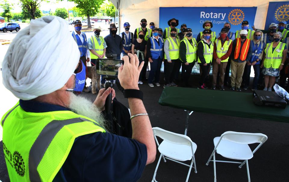 Rotarian Ravitej Khalsa, left, takes a group picture of fellow Rotary volunteers at the end of their last shift of helping at the Lane County pop-up vaccination clinic in the Lane County Fairgrounds parking lot on May 22, 2021.