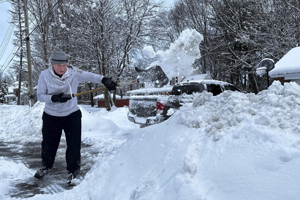 Michael Barbieri, 52, shovels snow from his driveway and sidewalk before going to work, Wednesday, March 15, 2023, in Pittsfield, Mass. The storm dumped heavy, wet snow on parts of the Northeast, causing tens of thousands of power outages. (AP Photo/Rodrique Ngowi)