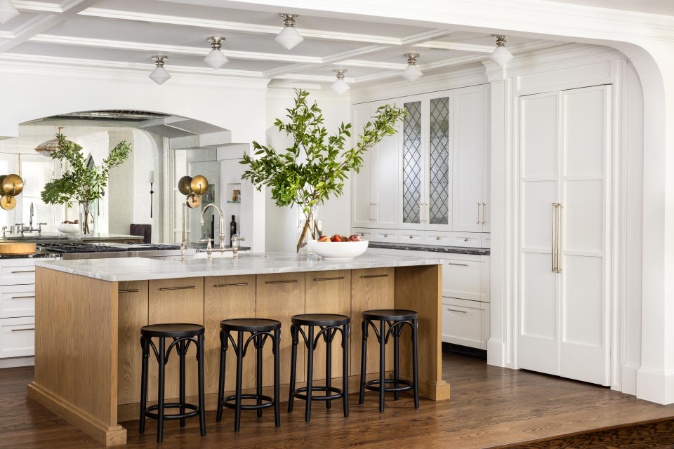 A kitchen with small stools placed under the island