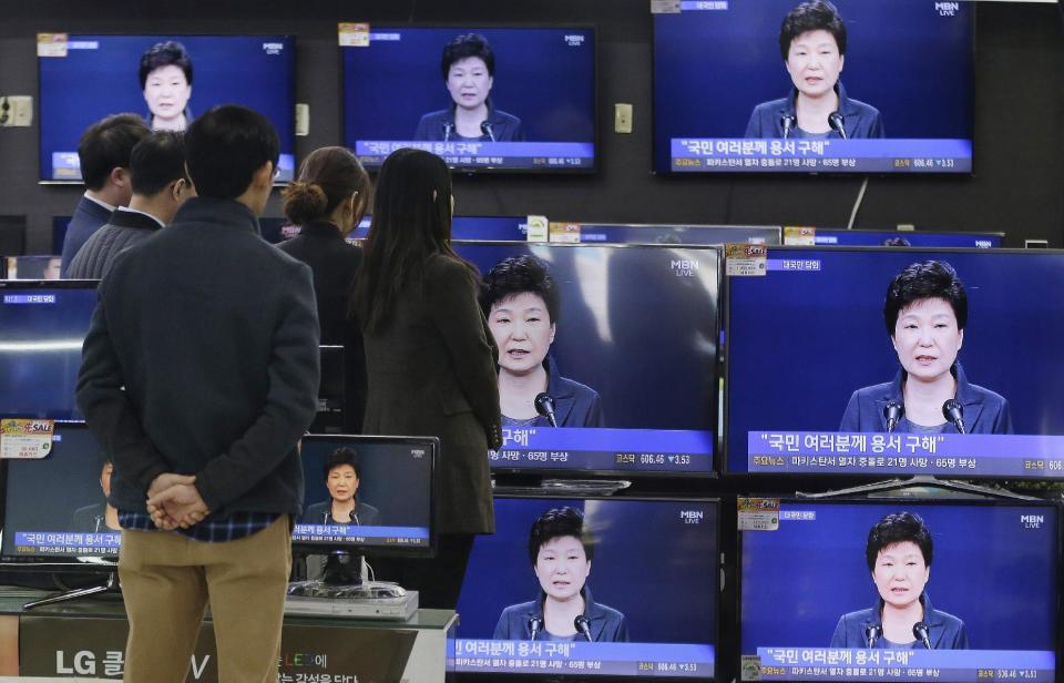 FILE - In the Nov. 4, 2016 file photo, people watch TV screens show the live broadcast of South Korean President Park Geun-hye's address to the nation at the Yongsan Electronic store in Seoul, South Korea. A lawyer for South Korea's disgraced president has compared her impeachment to the "unjust" deaths of Jesus Christ and the ancient Greek thinker Socrates. That might be over the top, but the country’s second impeachment trial will have major implications on the world’s 11th largest economy and its tense standoff with nuclear-armed North Korea. (AP Photo/Ahn Young-joon, File)
