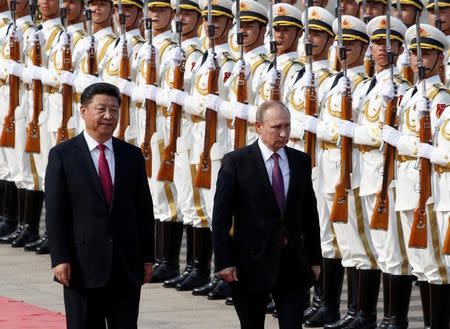 Russian President Vladimir Putin (R) and his Chinese counterpart Xi Jinping attend a welcoming ceremony outside the Great Hall of the People in Beijing, China, June 25, 2016. REUTERS/Kim Kyung-Hoon