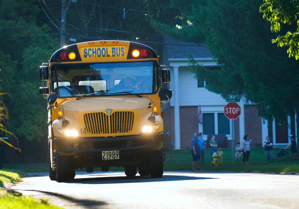 A Sycamore Community school bus picks up kids in a Blue Ash neighborhood for the first day of school at Blue Ash Elementary on Aug. 28, 2023.