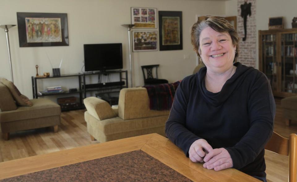 In this Feb. 3, 2014 photo, Maureen Grey poses for a photo in Chicago. For many older Americans who lost jobs during the recession, the quest for health care has been one obstacle after another. Grey, a 58-year-old Chicagoan, finally saw a doctor this month after a fall in September left her in constant pain. Laid off twice from full-time jobs in the past five years, she saw her income drop from $60,000 to $17,800 a year. Now doing temp work, she was uninsured for 18 months before she chose a marketplace plan for $68 a month. (AP Photo/M. Spencer Green)