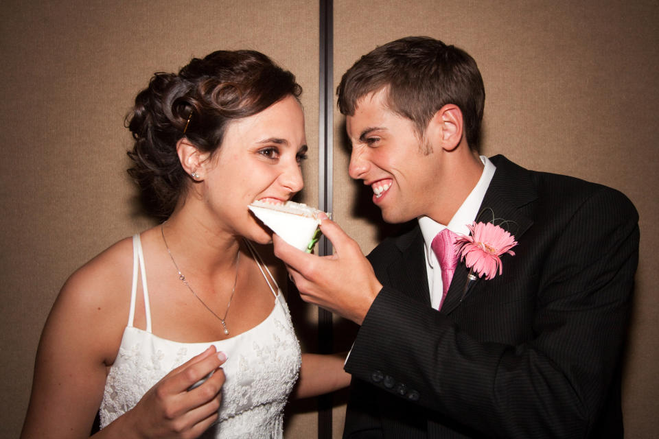 A groom feeding his bride a piece of cake