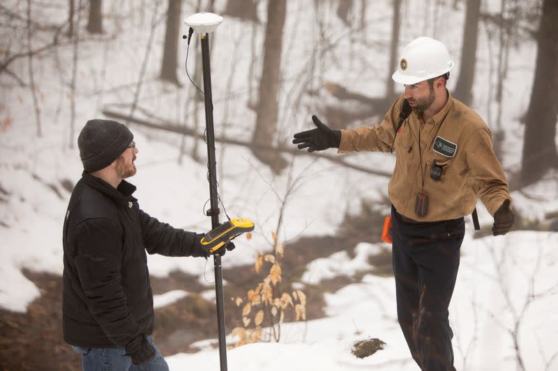 Timothy De Smet and Nathan Graber use a global navigation satellite system and geodetic antenna to locate abandoned oil wells in Olean, New York