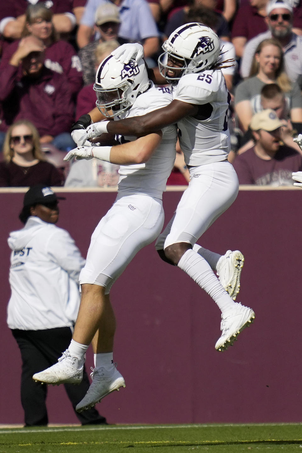 Abilene Christian linebacker Cirby Coheley, left, reacts with teammate Izaiah Kelley (25) after a pick-six touchdown against Texas A&M during the first quarter of an NCAA college football game Saturday, Nov. 18, 2023, in College Station, Texas. (AP Photo/Sam Craft)