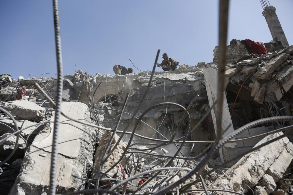 People inspect the rubble of a prison facility hit by a Saudi-led coalition airstrike that killed at least 87 people in a stronghold of Houthi rebels on the border with Saudi Arabia, in the northern Saada province of Yemen, Saturday, Jan. 22, 2022. Internet access remained largely down on Sunday after another Saudi-led coalition airstrike hit a telecommunications center Friday at the Red Sea port city of Hodeida. (AP Photo/Hani Mohammed)