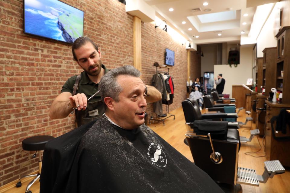 Customer Rayf Berman of Scarsdale says he would like to see good restaurants in the new development plans at the former Galleria mall site since he works nearby, while getting a haircut from owner Goni Gega at Handlebar Men's Salon, which is located across the street from the site, on Sept. 29, 2023.