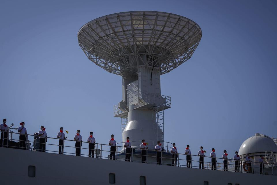 Crew of Chinese scientific research ship Yuan Wang 5 wave Chinese flags from the ship after arriving at Hambantota International Port in Hambantota, Sri Lanka, Tuesday, Aug. 16, 2022. The ship was originally set to arrive Aug. 11 but the port call was deferred due to apparent security concerns raised by India. (AP Photo/Eranga Jayawardena)