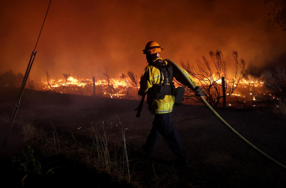 A firefighter monitors the Dixie Fire on August 16, 2021, near Janesville, California. / Credit: Justin Sullivan / Getty