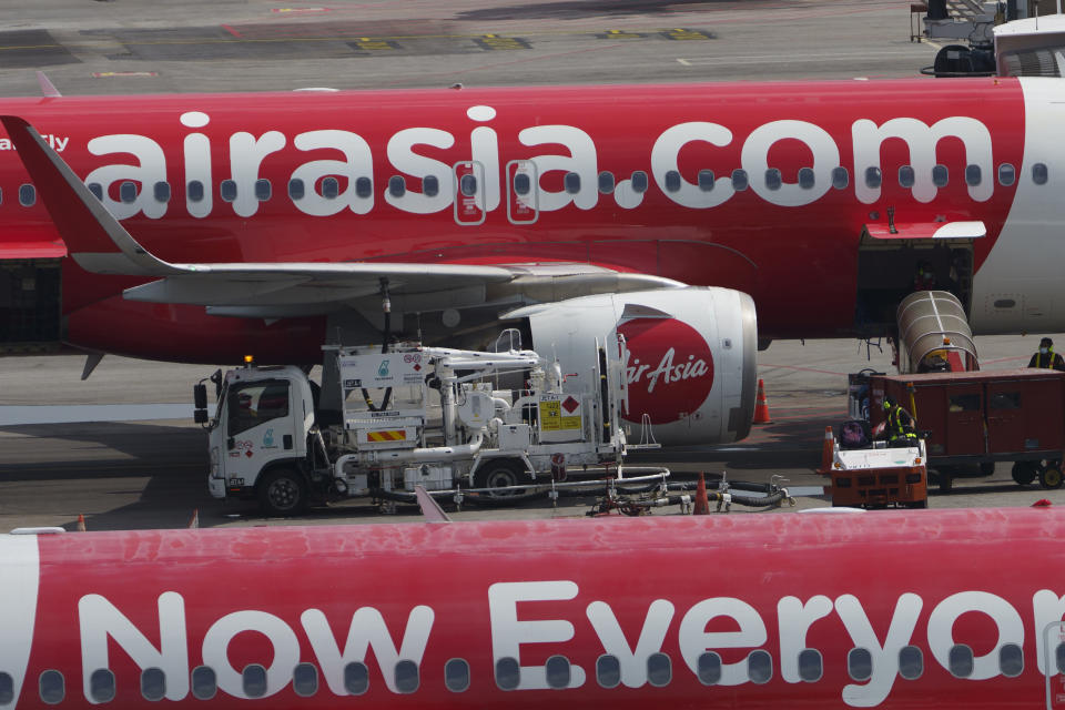 Ground staff refuel AirAsia planes as they sit on the tarmac at a terminal in Sepang, Malaysia, Monday, Nov. 15, 2021. Malaysia's AirAsia Group said Friday, Jan. 28, 2022, it has officially changed the name of its listed holding company to Capital A to reflect the diversity of its business portfolio as it seeks to grow its non-airline revenue. (AP Photo/Vincent Thian)