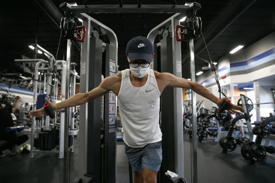 Benji Xiang, 32, wears a mask while working out at a gym in Los Angeles. Friday, June 26, 2020. With the coronavirus surging, at least four California counties on Friday paused or prepared to backtrack on their reopening plans in a bid to halt the spread of the virus. (AP Photo/Jae C. Hong)