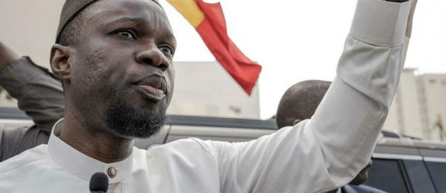 Ousmane Sonko répond aux journalistes depuis son convoi sur le chemin de son procès à Dakar le 16 mars 2023.  - Credit:ANNIKA HAMMERSCHLAG / Anadolu Agency via AFP