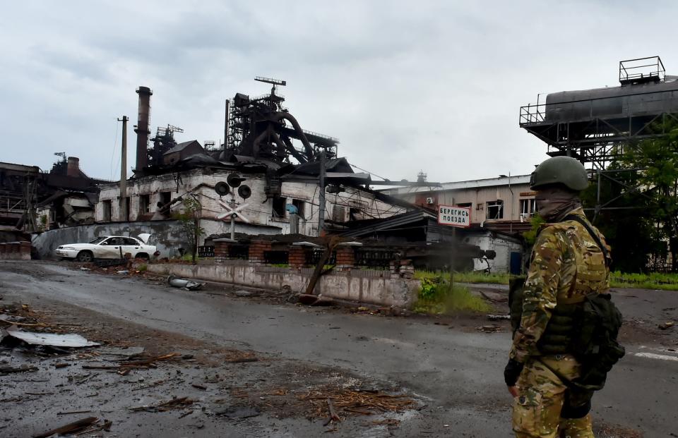 A Russian serviceman stands guard at the destroyed part of the Ilyich Iron and Steel Works in Ukraine's port city of Mariupol on May 18, 2022, amid the ongoing Russian military action in Ukraine. (Photo by Olga MALTSEVA / AFP) (Photo by OLGA MALTSEVA/AFP via Getty Images)