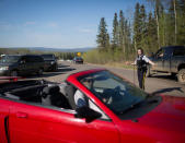 A police officer directs traffic as residents of Fort McMurray assemble after they were ordered to be evacuated due to raging wildfires, in Anzac, Alberta, Canada May 4, 2016. REUTERS/Topher Seguin