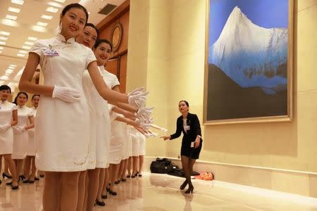 Hostesses pose for photos during a break from the G20 Finance Ministers and Central Bank Governors meeting in Chengdu in Southwestern China's Sichuan province, Sunday, July 24, 2016. REUTERS/Ng Han Guan/Pool